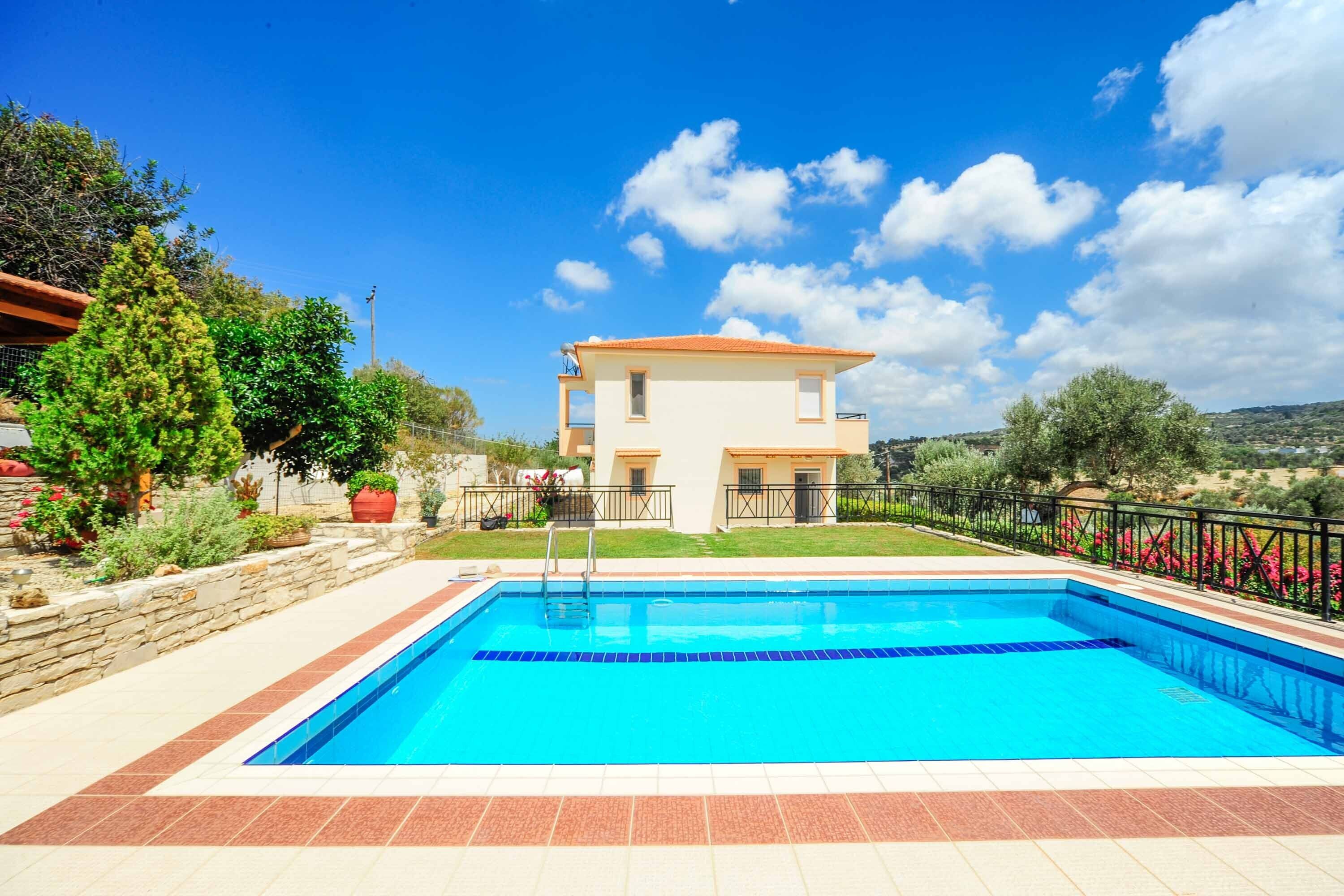 Une maison à deux étages avec une piscine à l’avant.