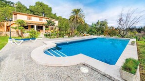 A swimming pool with a curved edge, surrounded by a stone deck. - Ca na Tonina - Five Bedroom Villa, Sleeps 10 (Pollença)