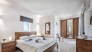 Une chambre moderne avec un lit en bois, des tables de chevet, un bureau et un grand miroir.