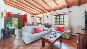 A spacious living room with a high ceiling, large windows, and a cozy seating area. - Villa Vobis - Three Bedroom Villa, Sleeps 6 (Mallorca)