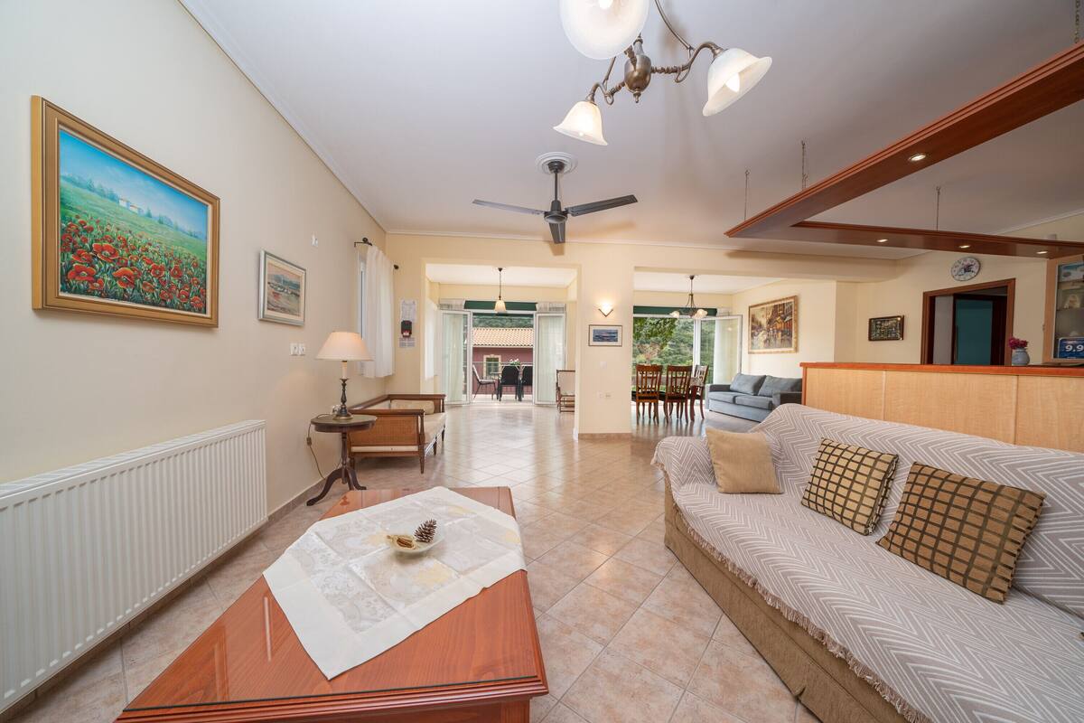 A spacious living area with a sofa, a wooden coffee table, and a ceiling fan.