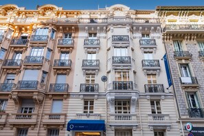 A multi-story building with ornate balconies and a blue awning with the name 'CRISOL MOZART'. - Crisol Mozart (Nice)