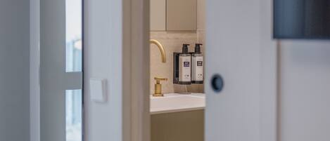 A bathroom with a mirror, a sink, and a towel rack.