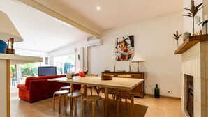 A modern kitchen with a dining table, chairs, and a red sofa.