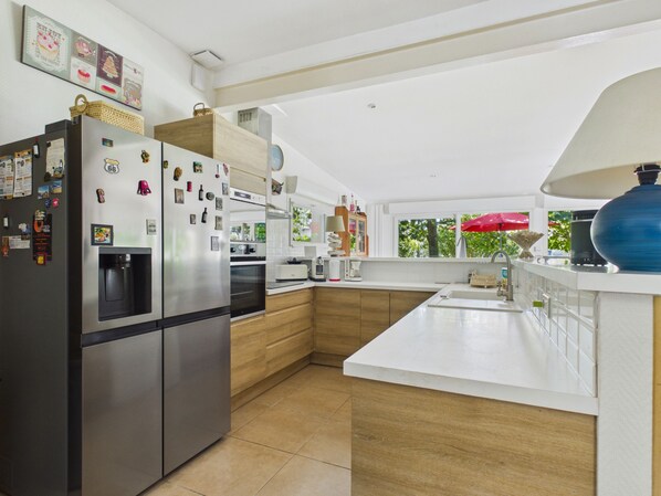 A modern kitchen with a built-in refrigerator, a water dispenser, and wooden cabinets.