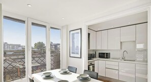 Una cocina moderna con armarios blancos, un microondas y un lavamanos.