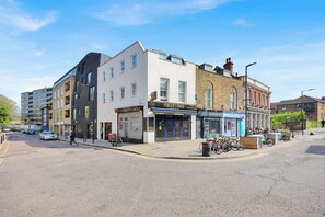 A street with buildings, including a shop named 'Porter's Path' and a cafe. - Trendy 1 Bedroom flat on Broadway Market! (Greater London)