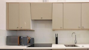 Une petite cuisine équipée d’un four à micro-ondes, d’un grille-pain, d’un évier et d’un lave-vaisselle.
