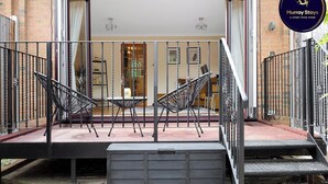 Un patio con mobiliario exterior, una escalera y un letrero que dice 'Murray Stays'.