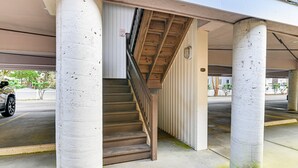 A parking garage with concrete pillars, a staircase, and a parked car. - 1 Mi to Boardwalk & Dtwn: Myrtle Beach Condo (Myrtle Beach)