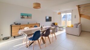 Een moderne keuken met een eettafel, stoelen en een houten kast.