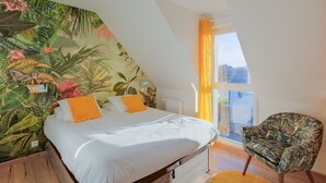 Een slaapkamer met een bed, een stoel, een raam met gordijnen en een muurschildering.