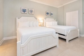 Une chambre avec deux lits, une table de chevet et des œuvres d’art murales.