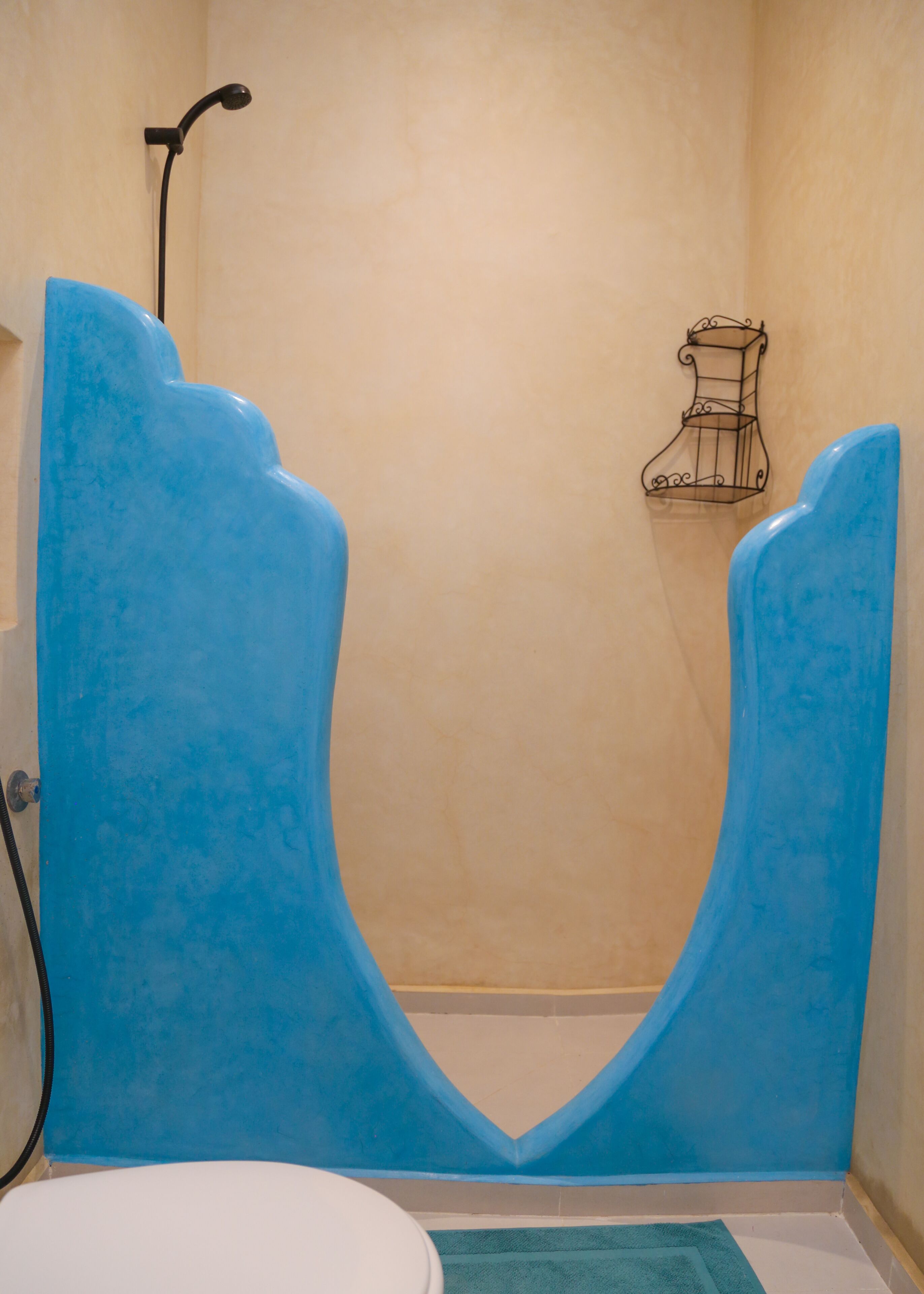 Ein Badezimmer mit einer blauen Badewanne, einer weißen Toilette und einem Handtuchhalter.