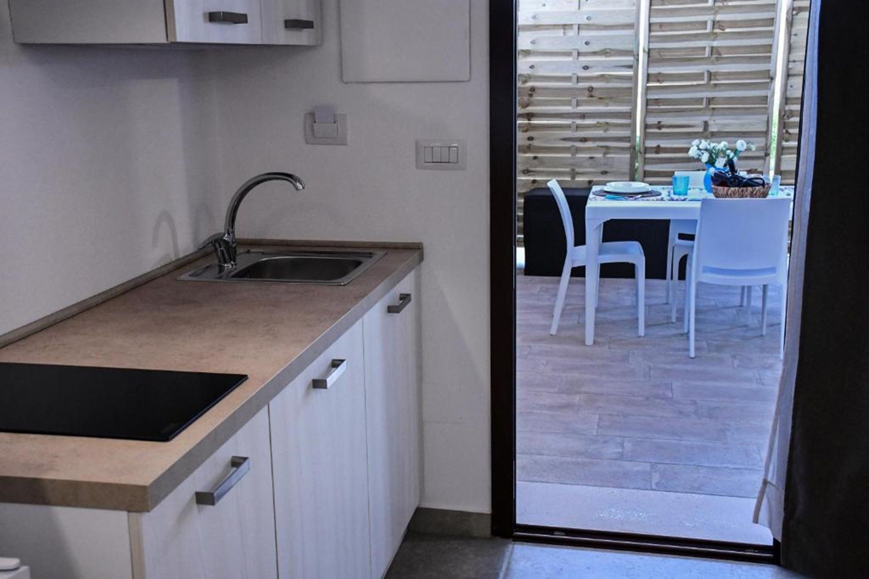 A compact kitchen with a sink, countertop, and cabinets.