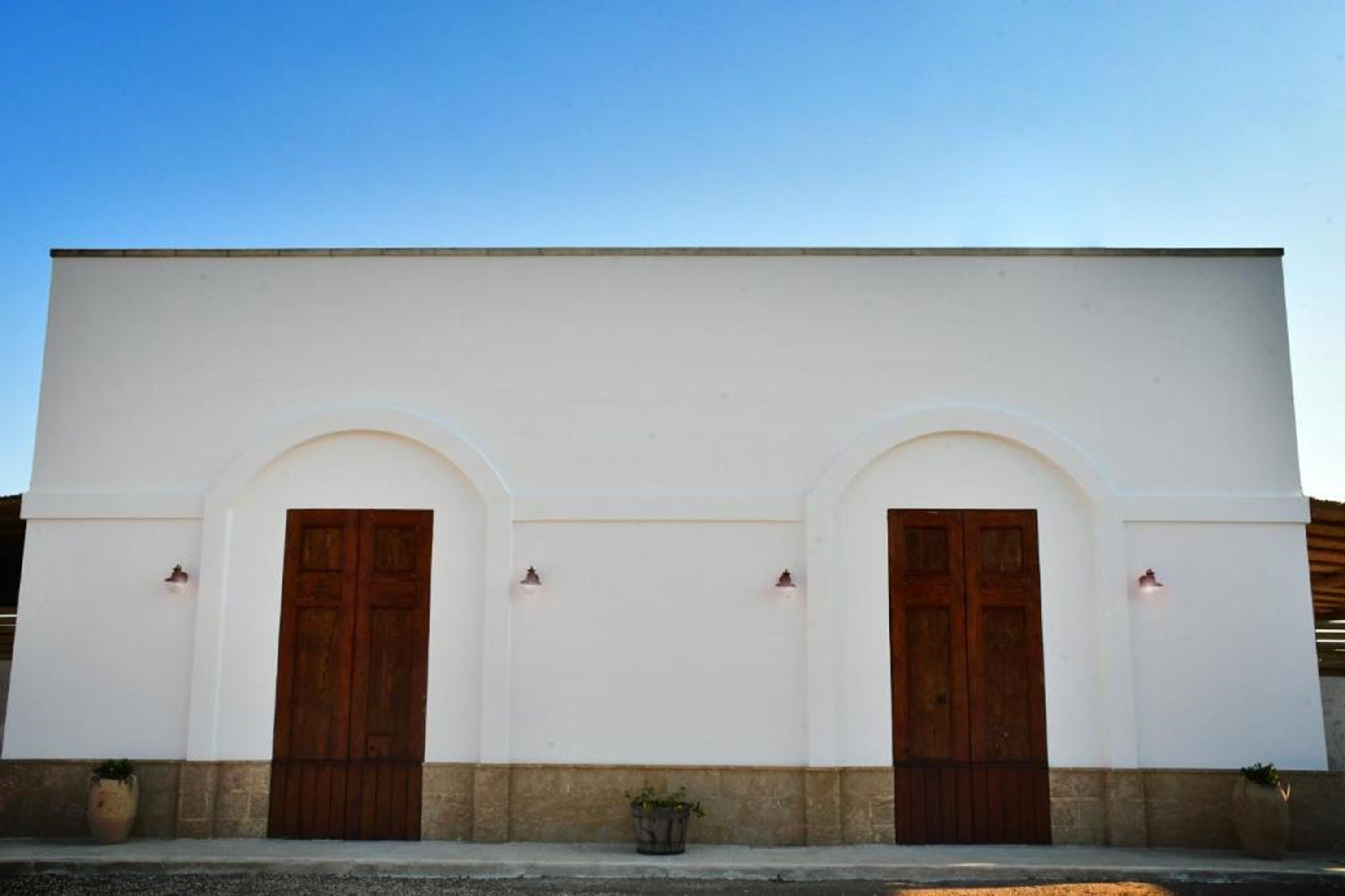 A building with two symmetrical arched doorways and a flat facade.