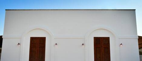 A building with two symmetrical arched doorways and a flat facade.