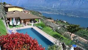 A poolside area with a view of a lake and mountains.
