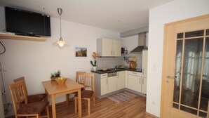 Una cocina compacta con armarios de madera, una mesa de comedor y sillas.