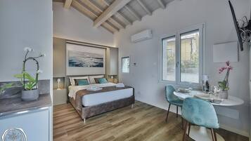 A modern bedroom with a bed, bedside table, and a desk with chairs.