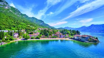 A lakeside town with buildings along the shore and mountains in the background.