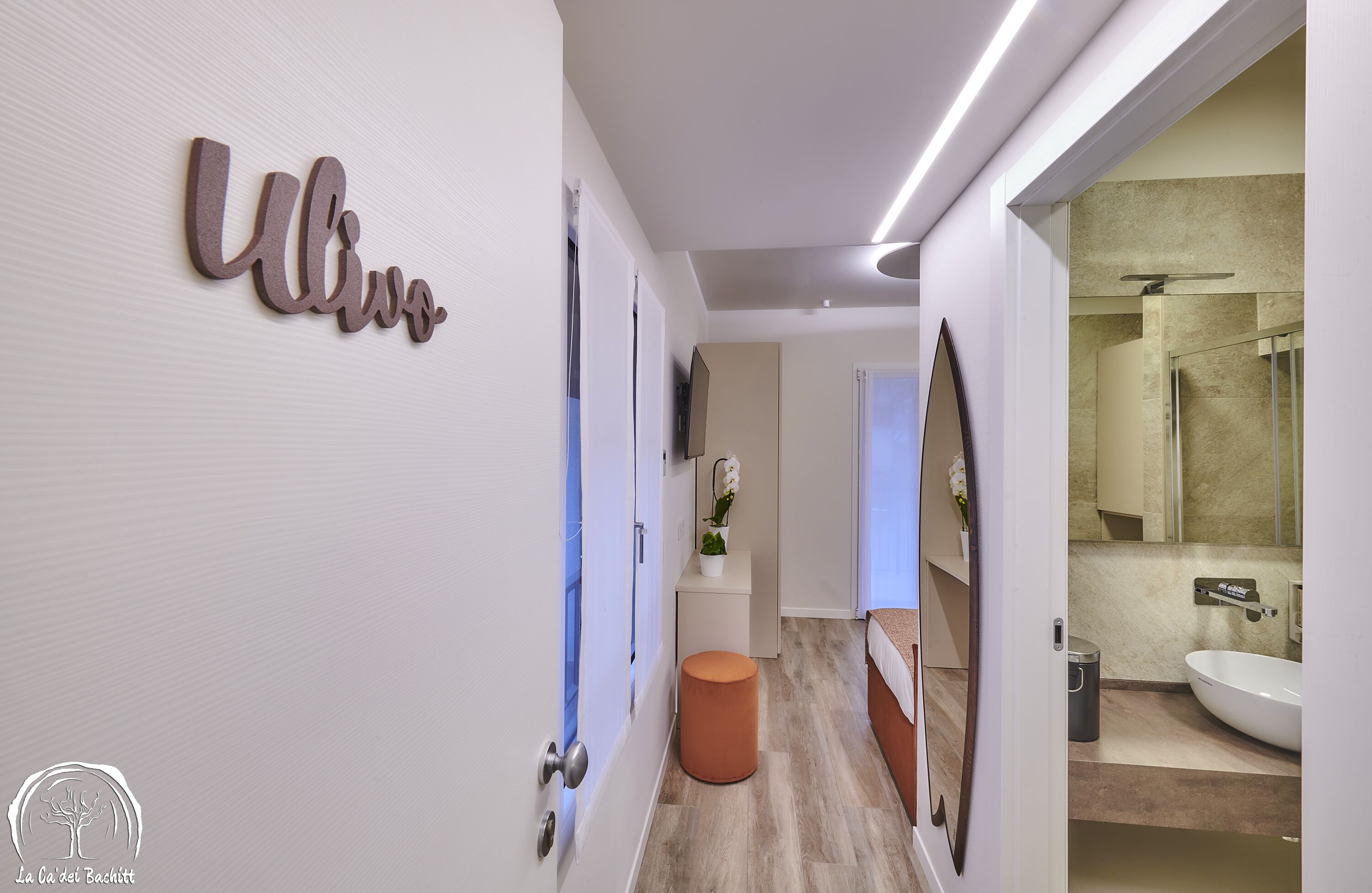 Un baño moderno con un espejo grande, un lavabo y una zona de ducha.