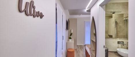 Un baño moderno con un espejo grande, un lavabo y una zona de ducha.