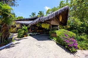 A tropical resort with thatched-roof structures, cobblestone pathways, and lush greenery. - Hotel Sombra e Água Fresca (Tibau do Sul)