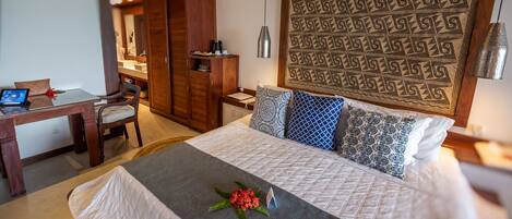A neatly arranged hotel room with a bed, a desk, and a wardrobe.