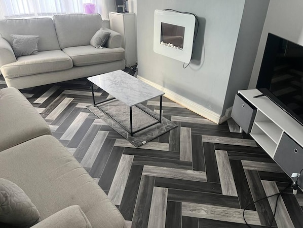 Relax in a comfortable seating area with a sofa set, flat-screen TV, and sleek coffee table.