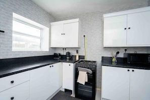 Enjoy cooking in this well-equipped kitchen with a gas stove, microwave, and kettle.