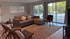 A living room with a sectional sofa, a wooden coffee table, a patterned rug, and a chair.