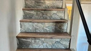 A staircase with stone steps and wooden handrails.