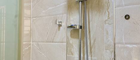 A shower with a handheld showerhead and a handheld faucet.