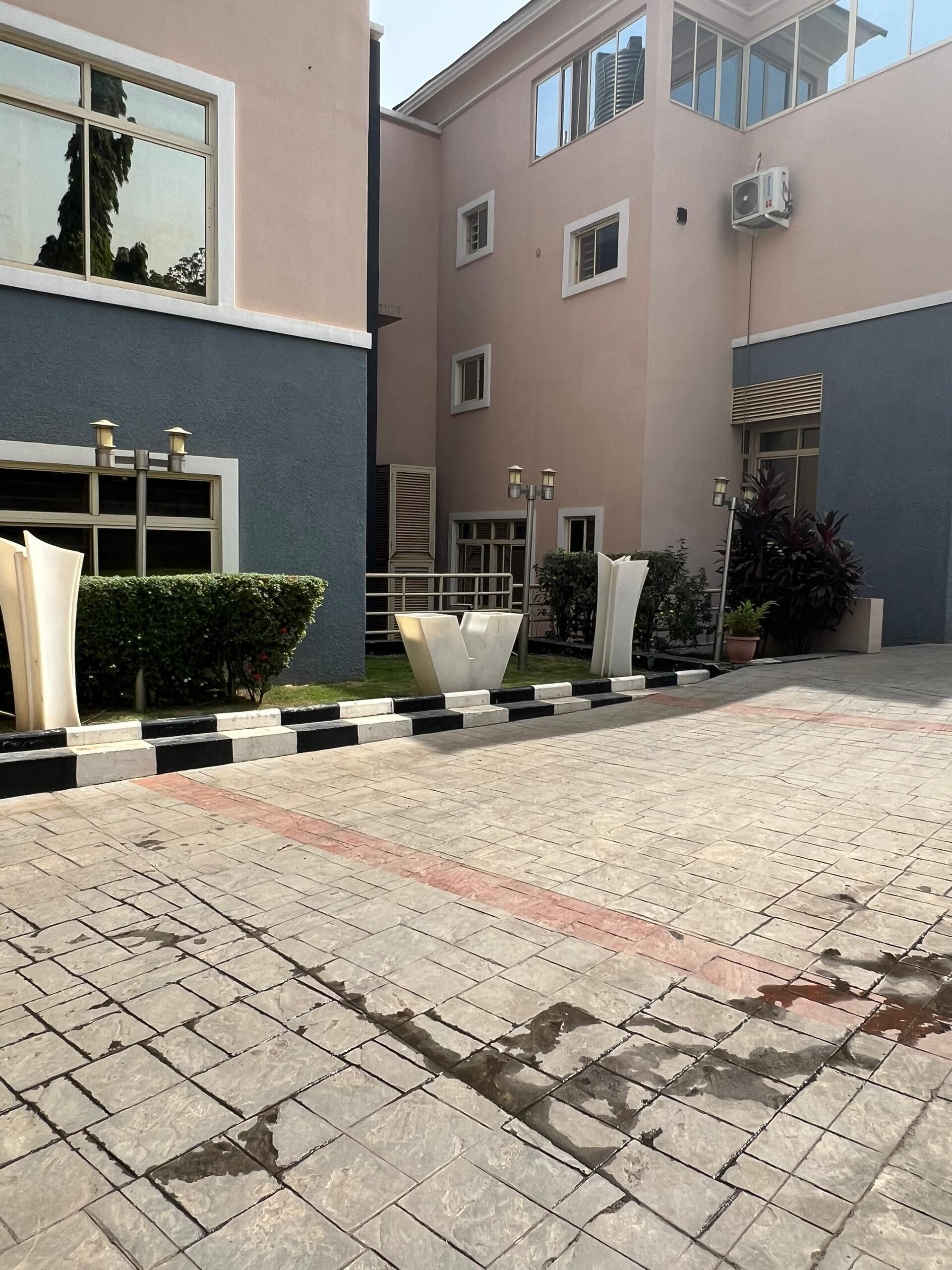 Un bâtiment doté d’une cour dallée, de nombreuses fenêtres et d’un éclairage extérieur.