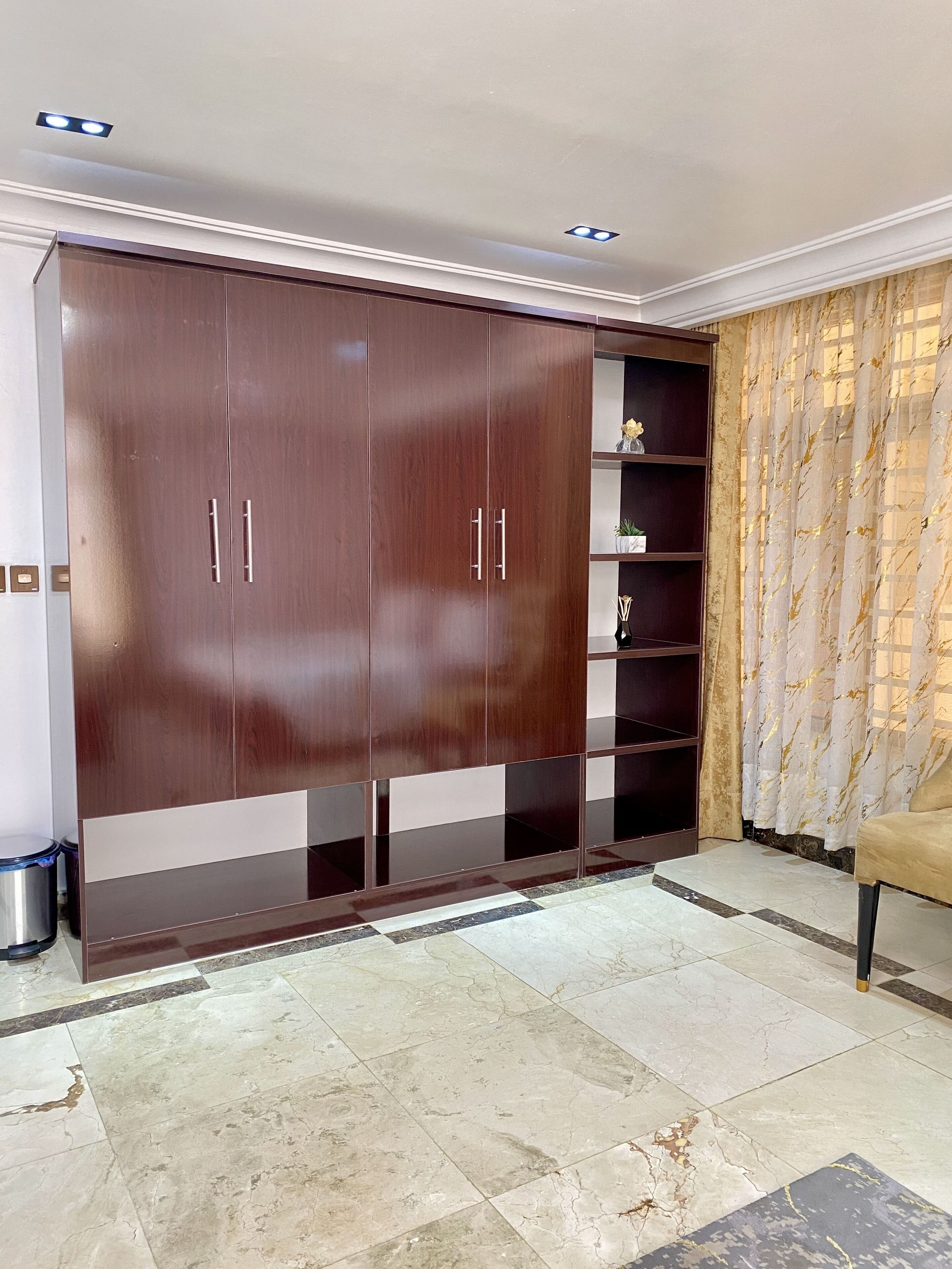 A spacious room with a large wardrobe, a sofa, and a curtain.