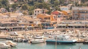 Un port esportiu amb embarcacions amarrades, envoltat d'edificis residencials i arbres.