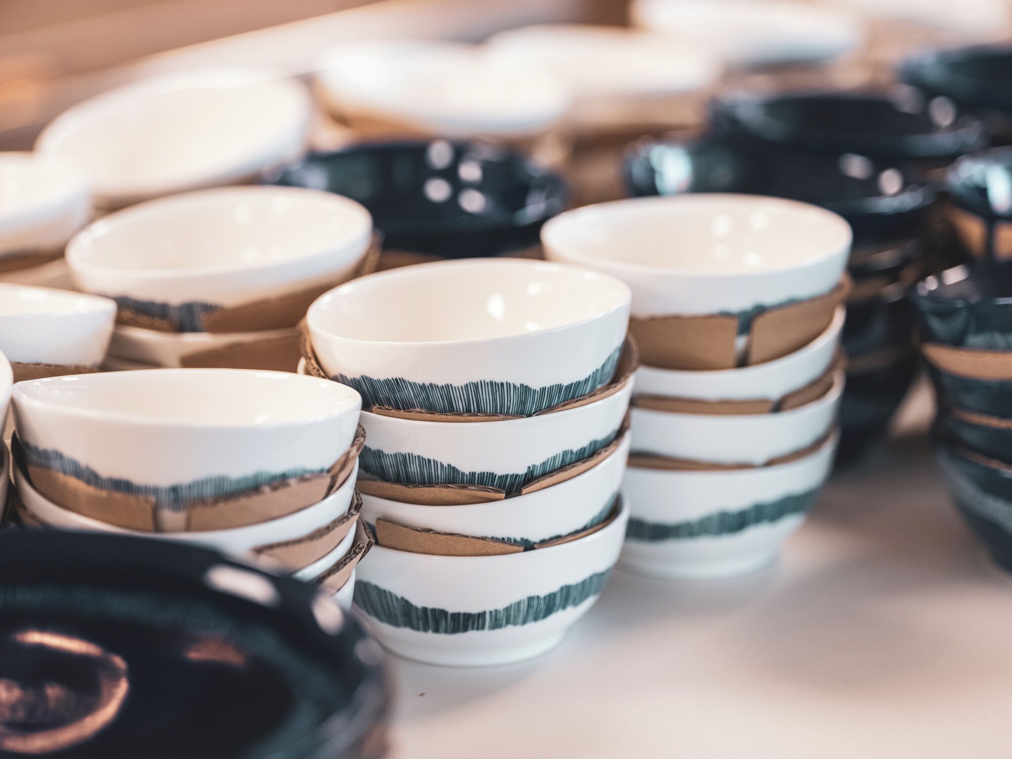 A collection of ceramic bowls with horizontal stripes in various colors.