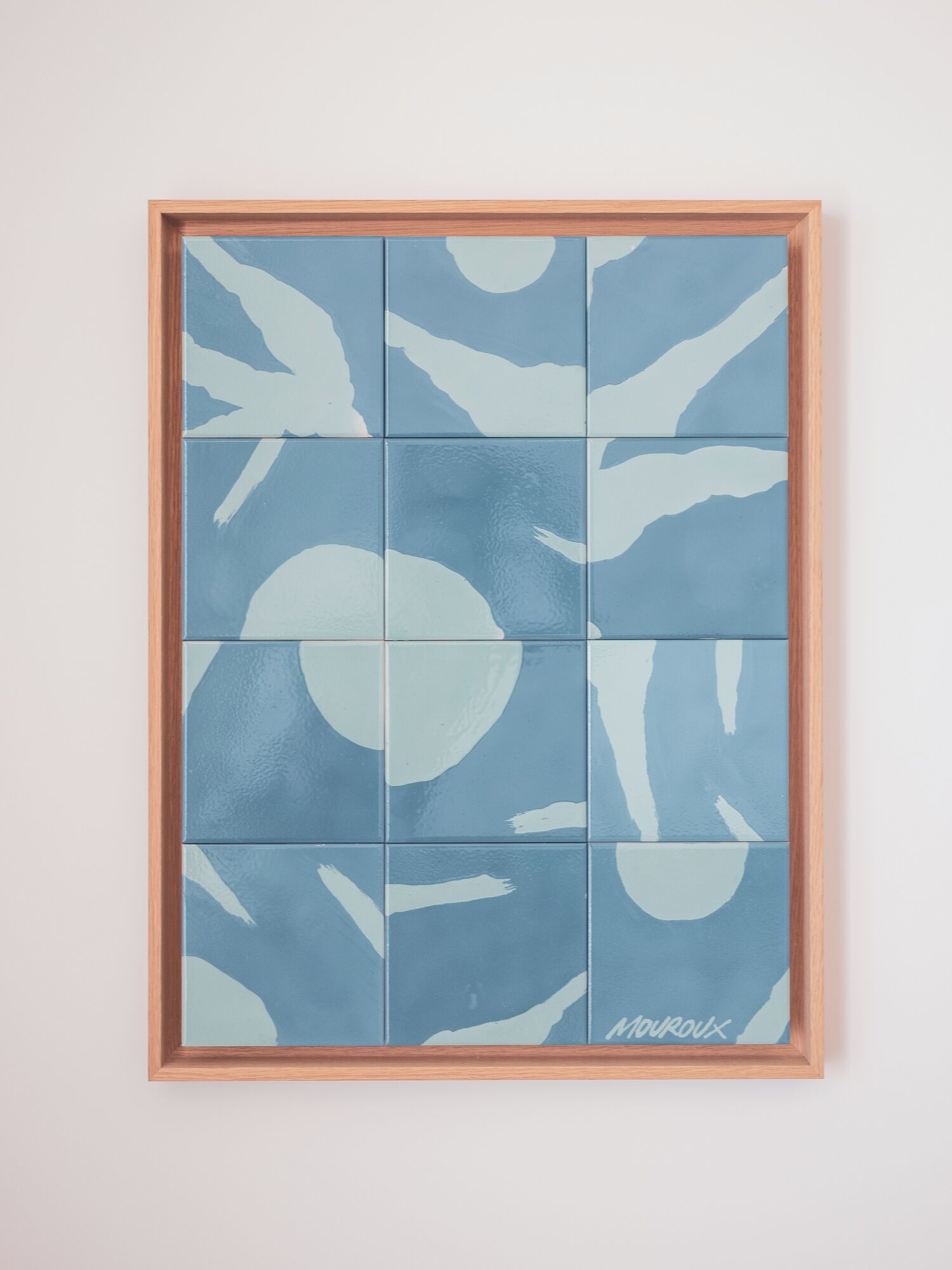 A framed artwork with abstract blue and white patterns.