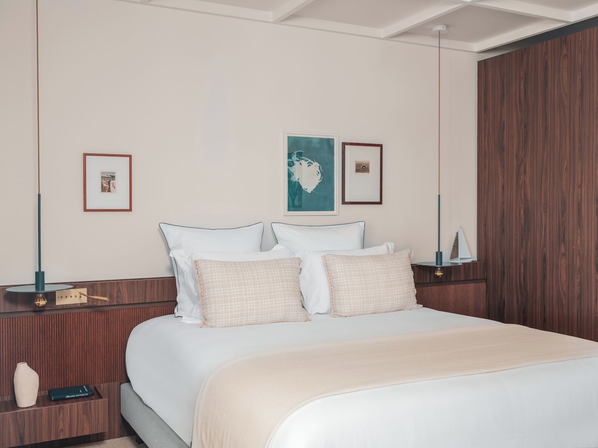 A neatly arranged bedroom with a large bed, two bedside tables, and a wooden wardrobe.