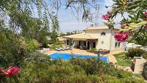 A house with a swimming pool, surrounded by lush greenery and a garden. - Vista da Montanha - Three Bedroom Villa, Sleeps 6 (Carvoeiro)
