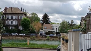 A residential street with a canal, parked cars, and houses. - Maison de Ville Avec Terrasse de 30 m2, Proche des Transports en Commun et Paris (Pomponne)