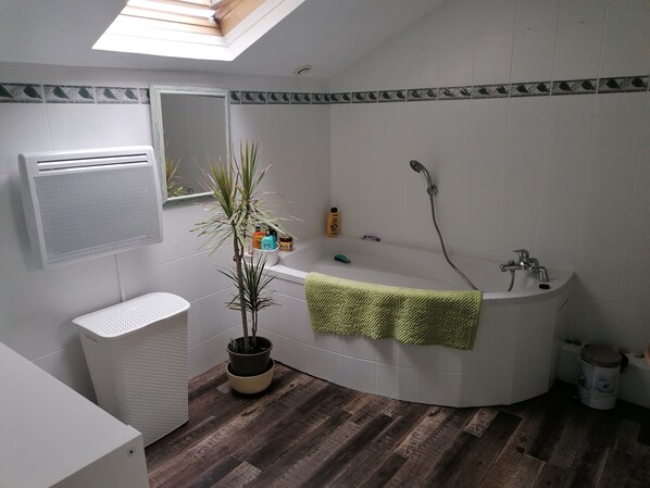 Une salle de bain moderne avec une baignoire sur pieds, une douche, des toilettes et un lavabo.