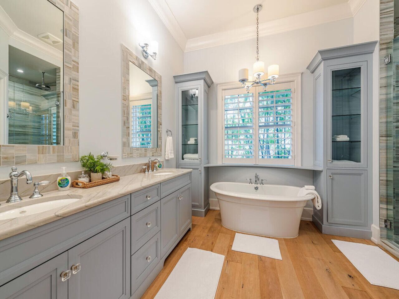 Un baño moderno con una bañera independiente grande, dos lavamanos y un mueble de tocador con armarios.