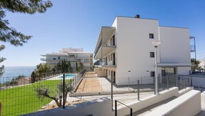 Ein modernes, zweistöckiges Gebäude mit flachem Dach und einem Balkon im oberen Geschoss, mit freiem Blick auf das Meer.