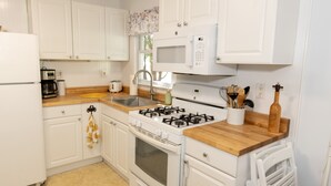 A kitchen with white cabinets, a gas stove, a microwave, and a wooden countertop. - NEW LISTING!!! Cedar Shade Beach Retreat (Lower Township)