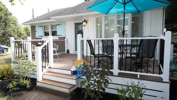 A covered porch with outdoor furniture, a blue umbrella, and a small birdhouse. - NEW LISTING!!! Cedar Shade Beach Retreat (Lower Township)