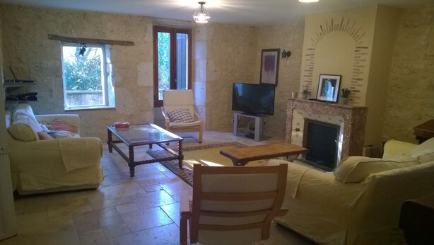 Una sala de estar con chimenea, televisión y sofá.