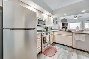 A modern kitchen with stainless steel appliances, wooden cabinets, and a built-in microwave. - Updated Branson Condo w/ Lake Taneycomo Views! (Branson)