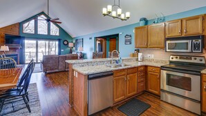 A spacious kitchen with wooden cabinets, a dishwasher, a microwave, and a large island with a sink. - Retreat w/ Dock & Views in Lake of the Ozarks (Gravois Mills)